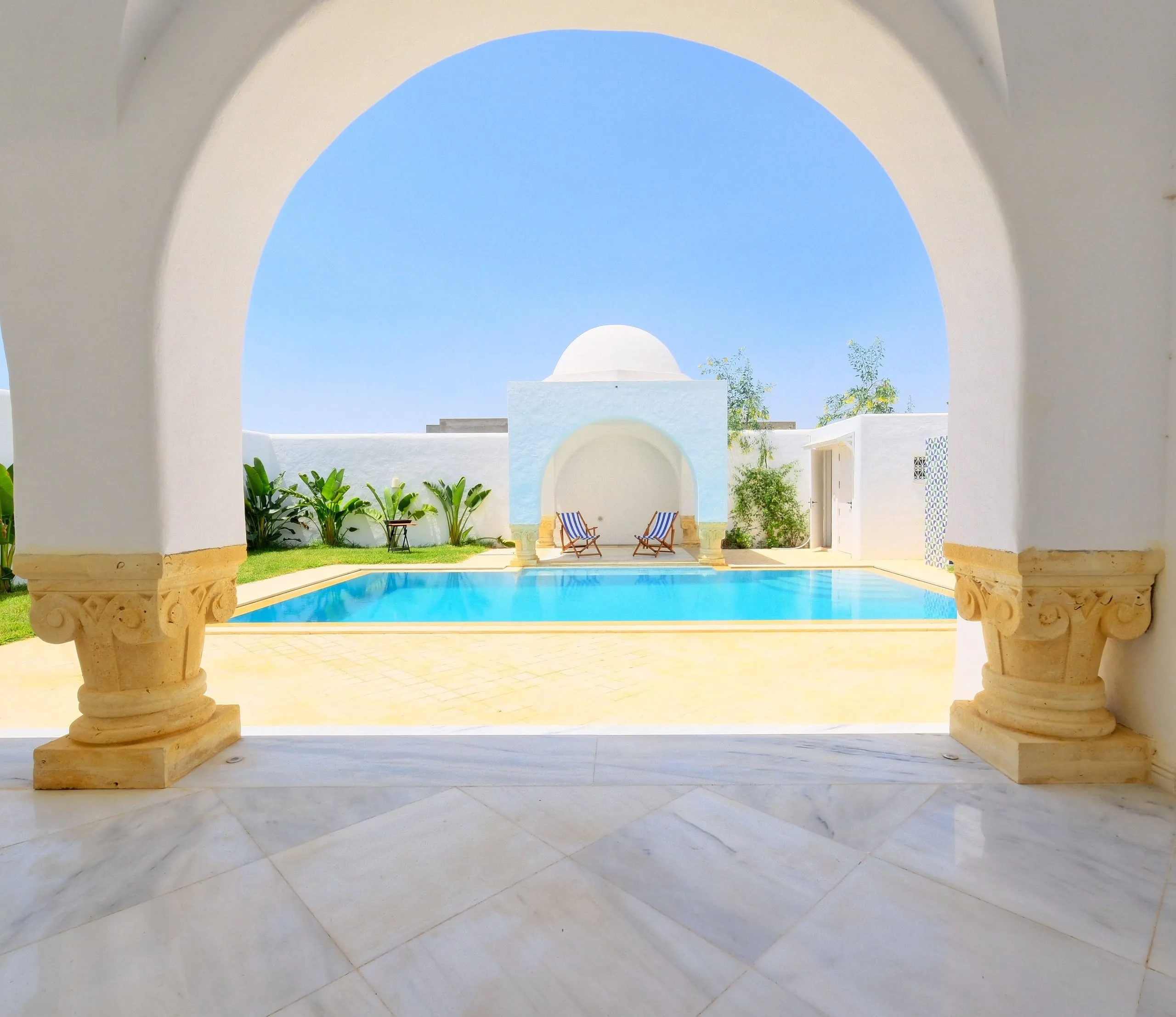 Der Pool durch die Bögen der Terrasse gesehen