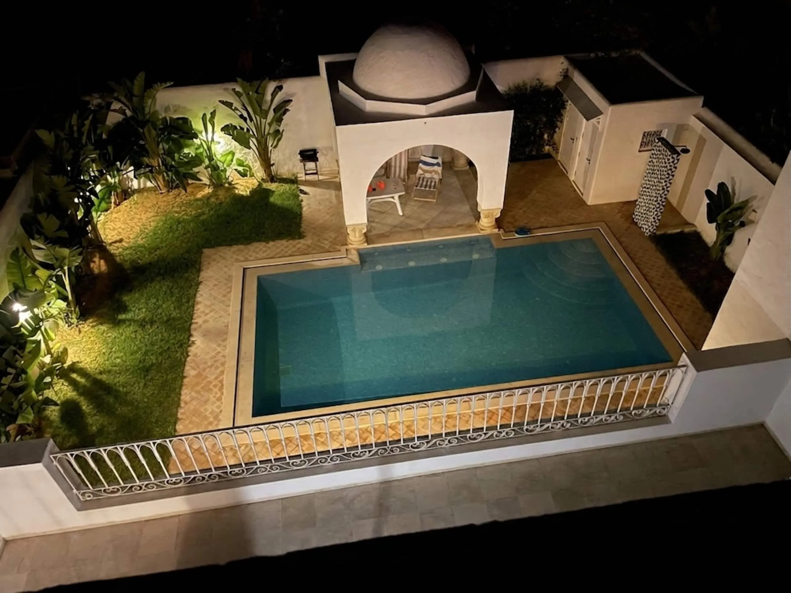 Nachtansicht auf Pool und Pavillon